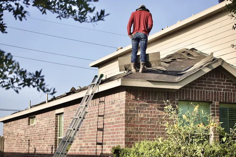 Professional roofer working on a residential roof in South End